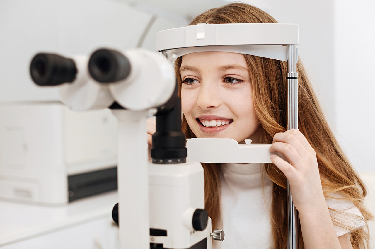 Young Girl Performing an Eye Exam while Smiling